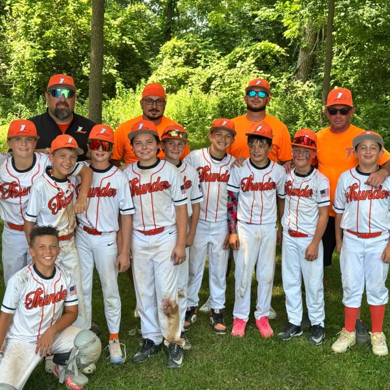 Thunder Baseball 12U players and coaches in white Thunder uniforms and orange caps